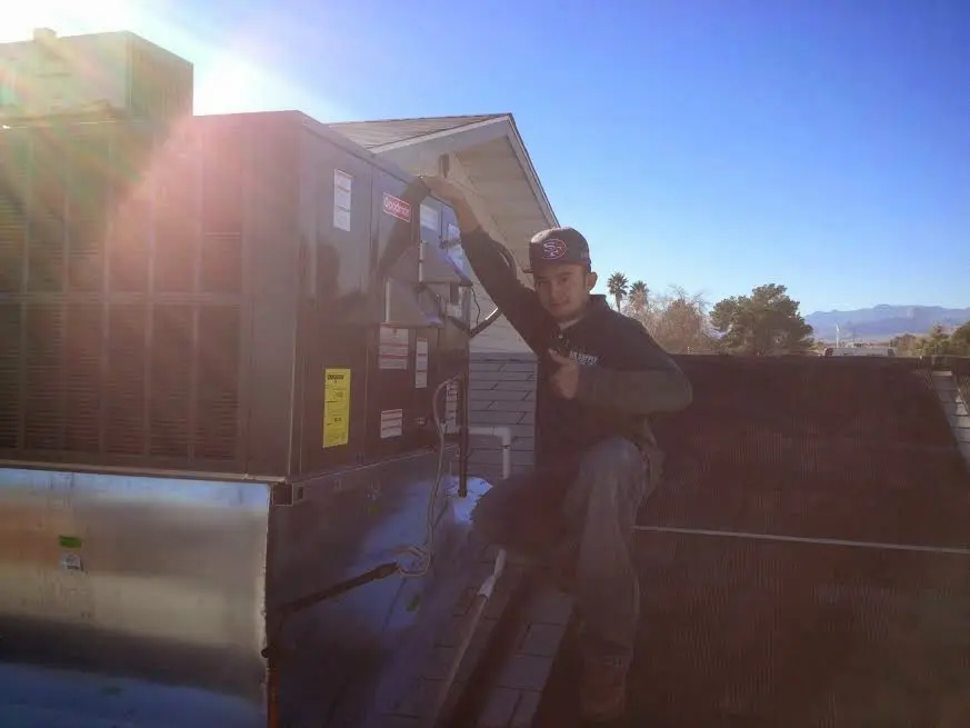 HVAC technician performing HVAC Inspection on a rooftop unit in Homestead Meadows South